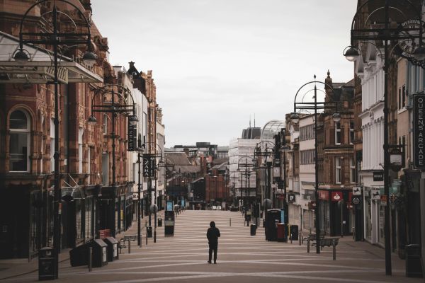 Solitary man walking down high street