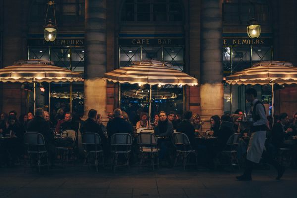 A wide shot of a long table in outside dining at night, lit up
