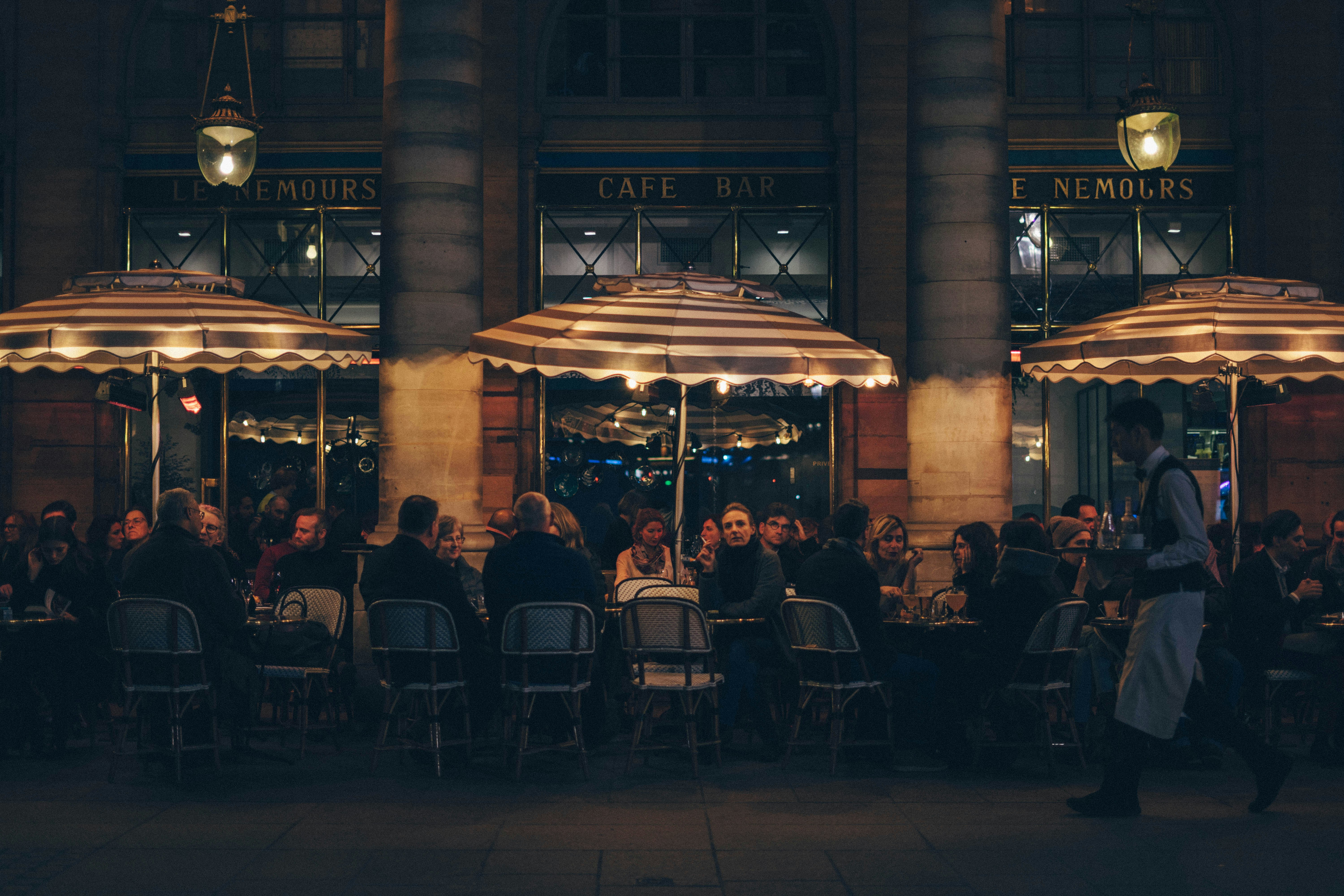 A wide shot of a long table in outside dining at night, lit up